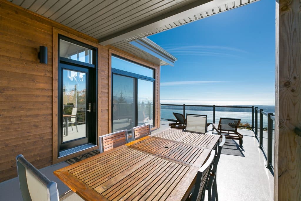 Galerie couverte avec table et BBQ et vue