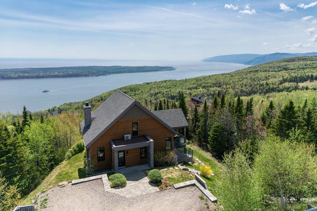 Vue aérienne du chalet La Panoramique à Charlevoix avec le fleuve Saint-Laurent en arrière-plan