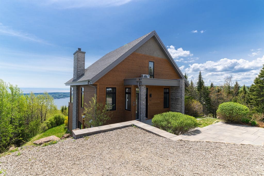 Vue de l'entrée La Panoramique en bois, architecture moderne et chaleureuse. Accès facile au chalet